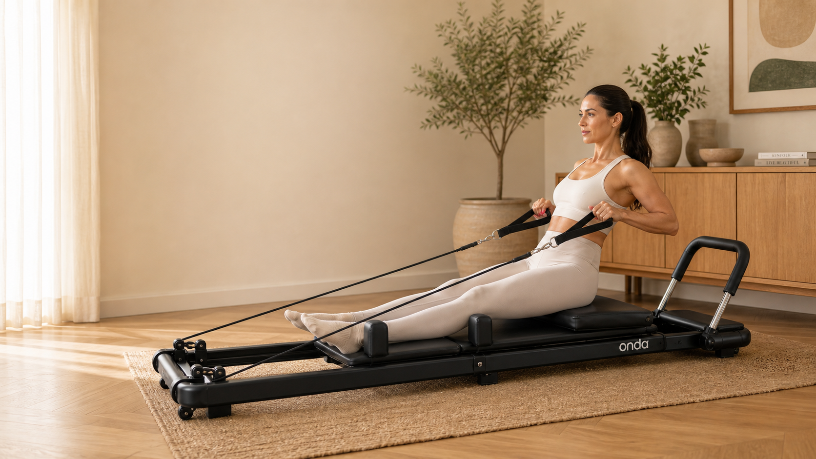 Woman using the Onda foldable Pilates reformer in a warm home studio