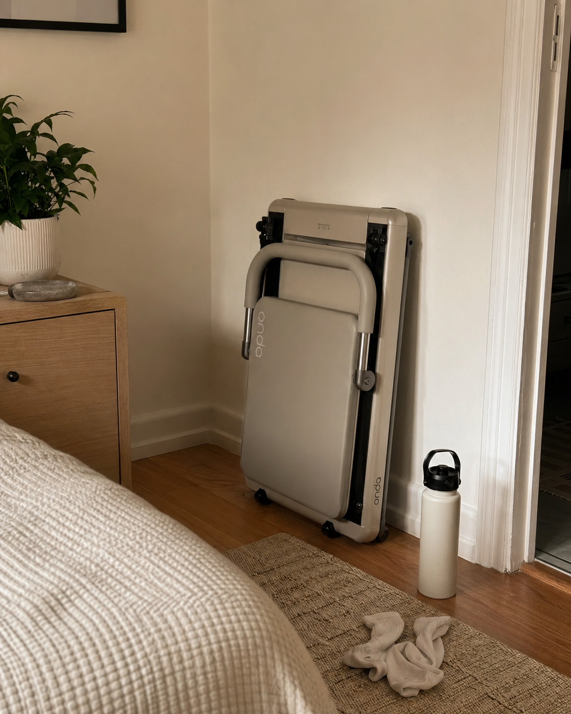 Warm ivory Onda reformer folded away in a bedroom corner